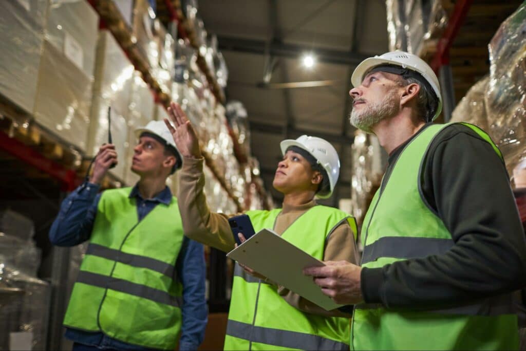 Warehouse team conducting inventory inspection and assessing stock levels.
