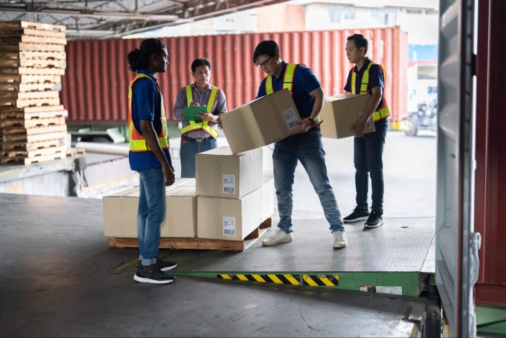 Delivery workers efficiently organizing boxes for shipping and logistics.