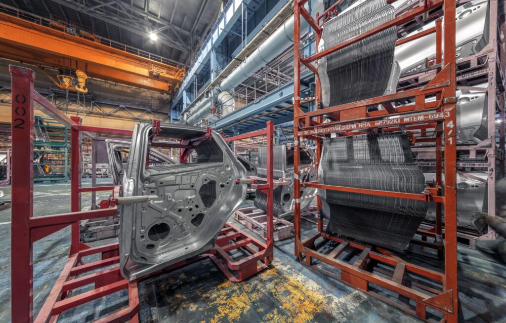 Automotive production line showcasing car parts and manufacturing equipment in an industrial setting.