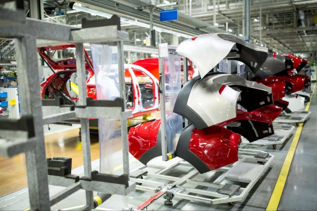 Car parts being assembled on a production line in a factory setting.