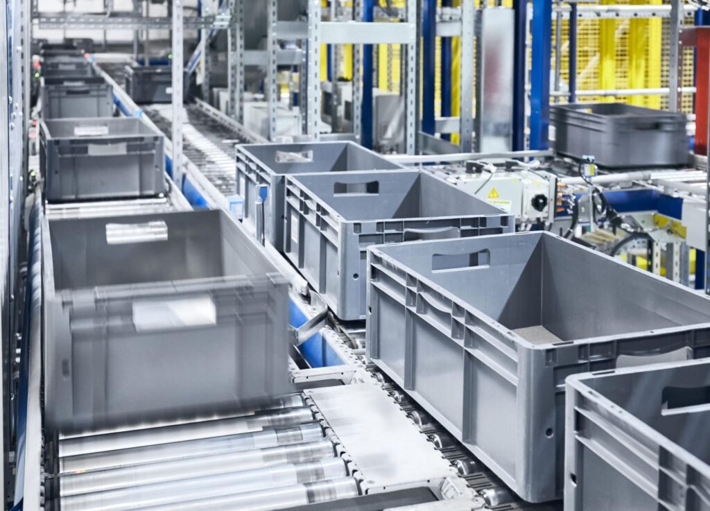 Automated conveyor system transporting bins in a warehouse environment.