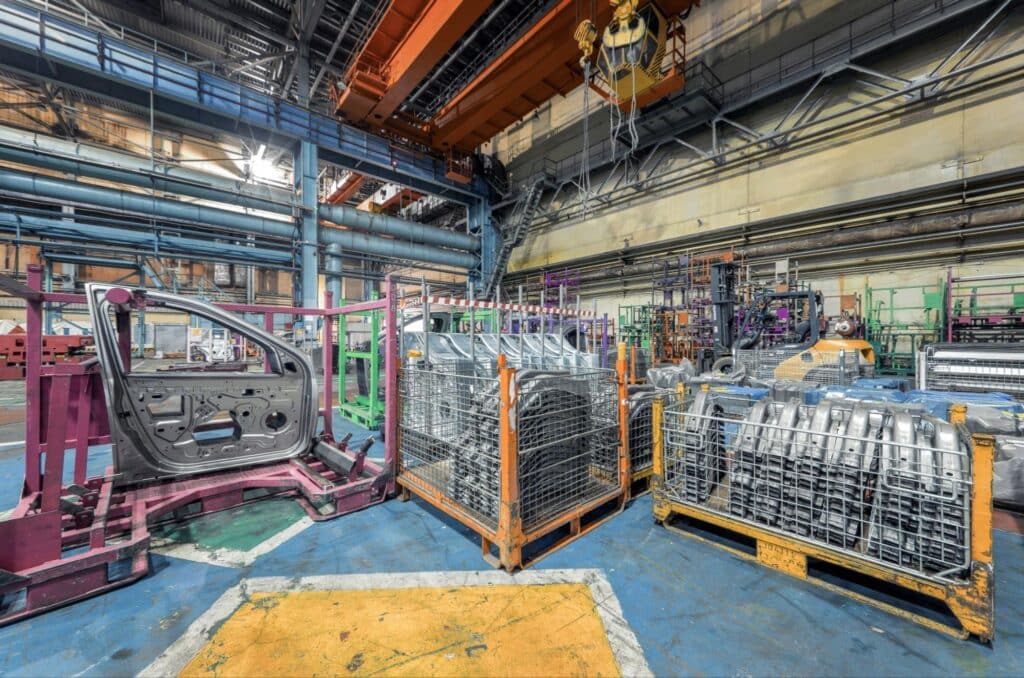 Vehicle parts manufacturing with machinery and tools in an industrial setting.