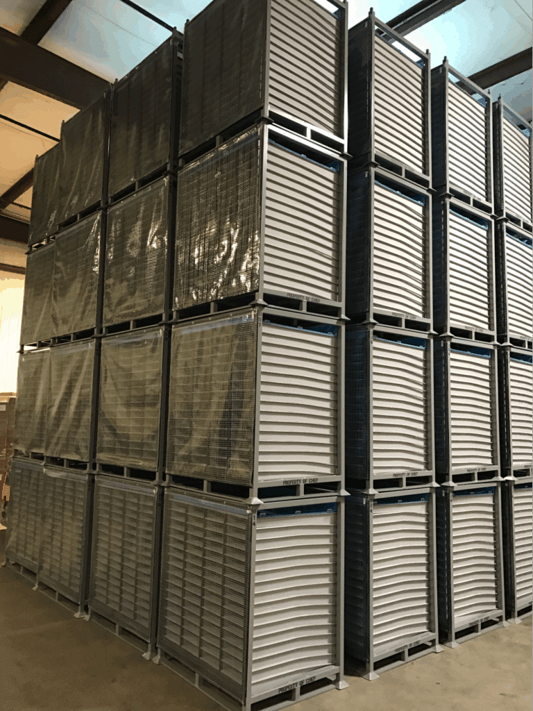 Metal storage containers stacked efficiently in a warehouse for optimal organization.