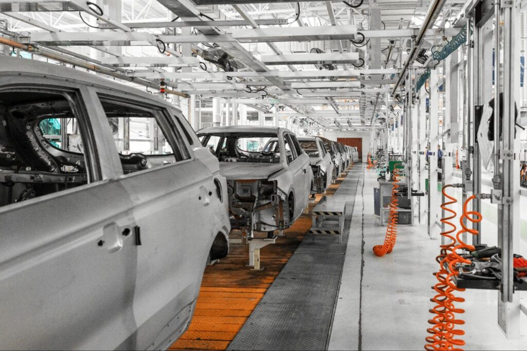 Automobile assembly line showcasing multiple car frames in a modern factory setting.