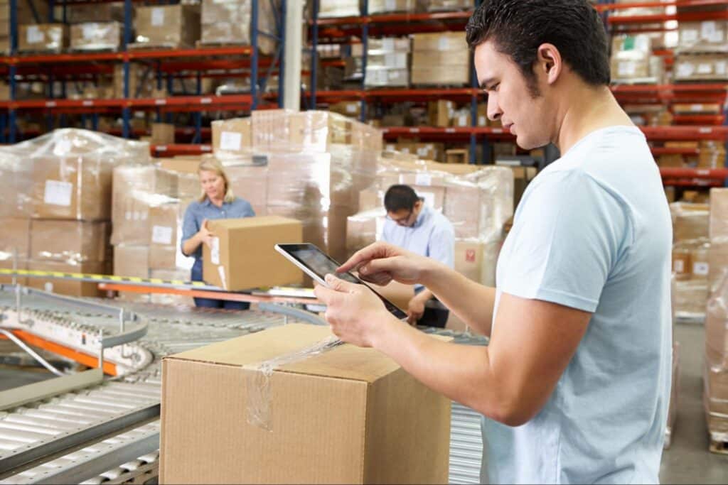 Warehouse worker scanning packages for inventory management efficiency.