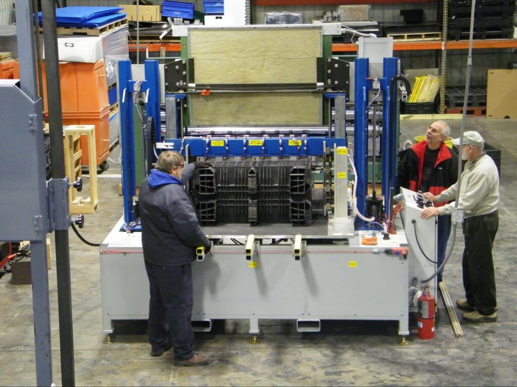 Workers using advanced machinery in a manufacturing environment.