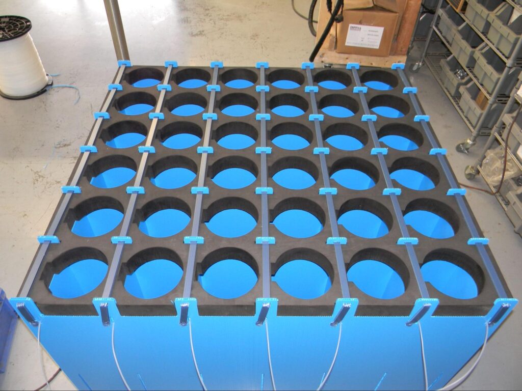 Reusable Dunnage used to store or ship cylindrical parts, featuring multiple circular cavities for precision.