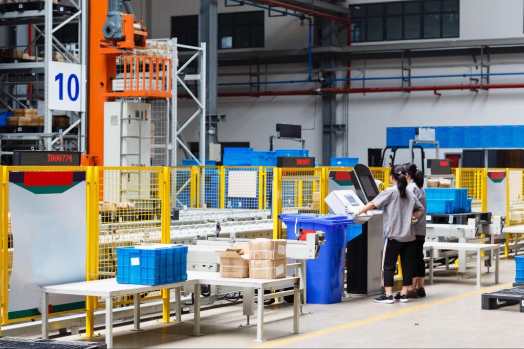 Workers managing Returnable Packaging in a modern warehouse environment.