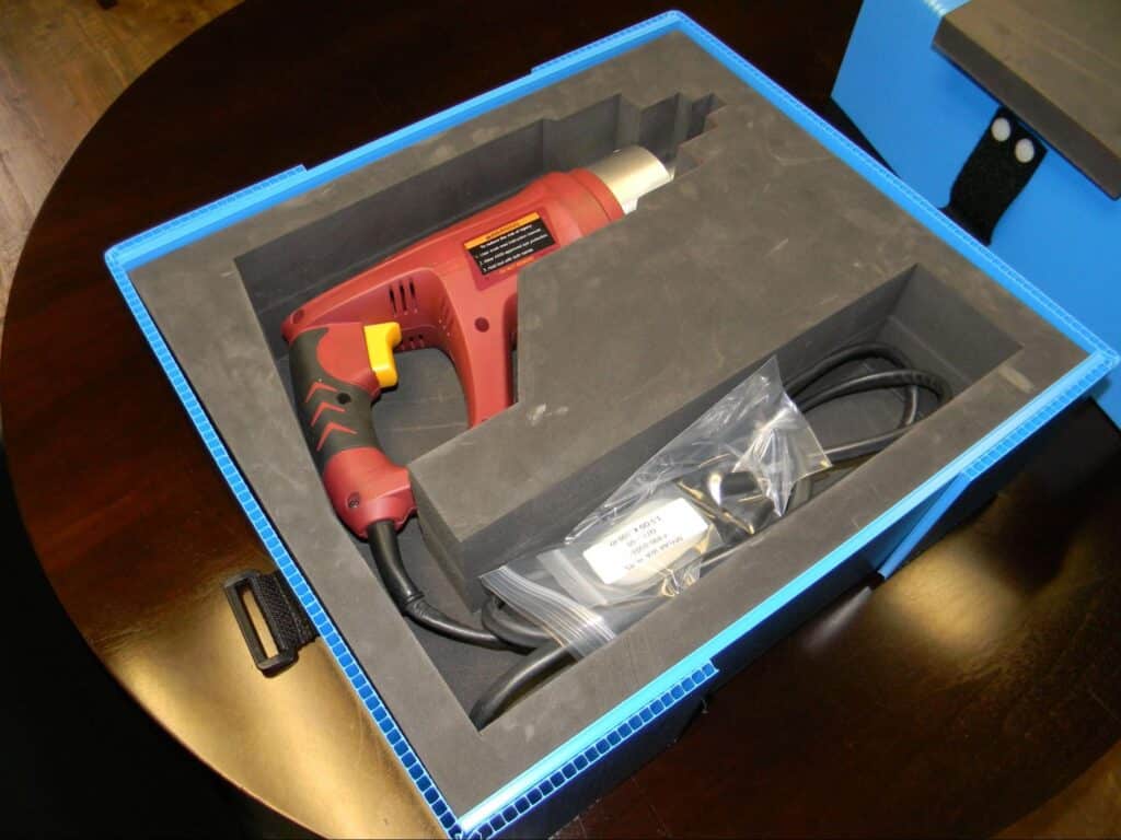 Heat gun stored securely in a blue protective box for safe transportation and storage.