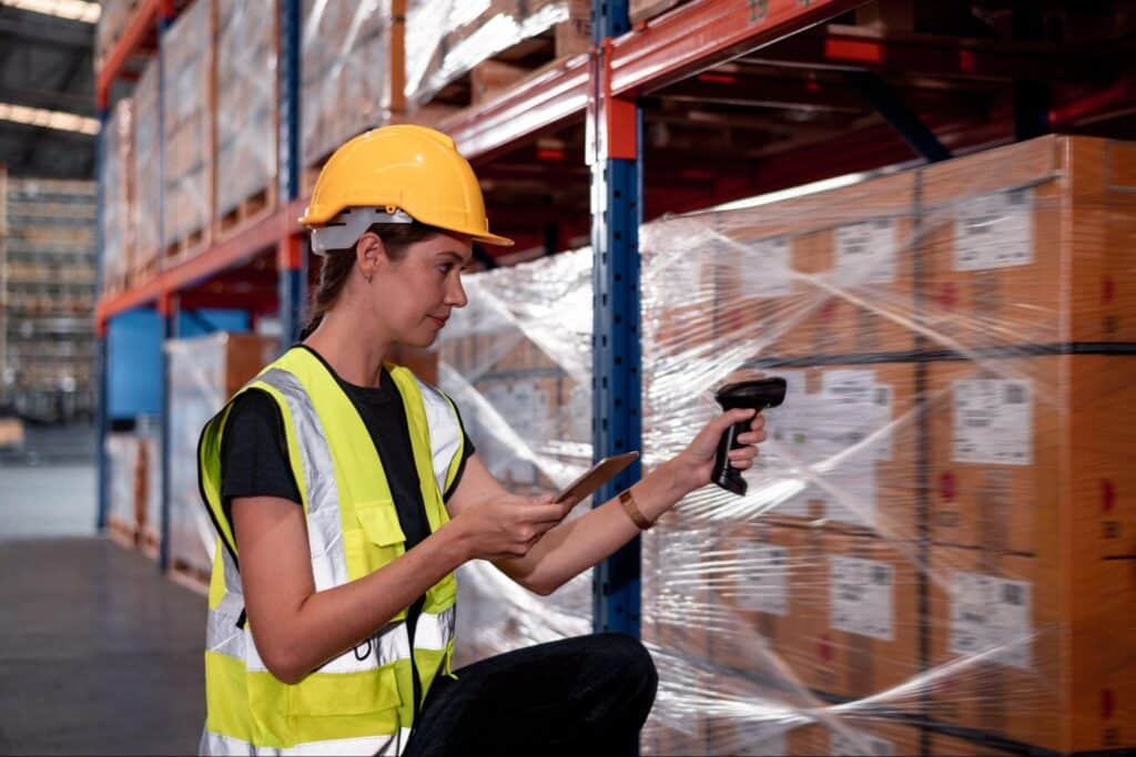 Woman using a barcode scanner to manage inventory in a warehouse.